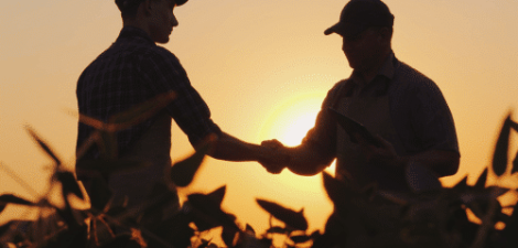 Two Farmers Shaking Hands in a Field